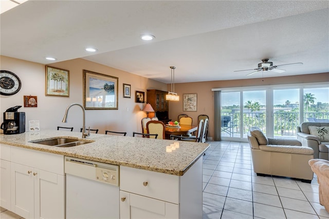 kitchen featuring white cabinetry, sink, hanging light fixtures, light stone counters, and white dishwasher