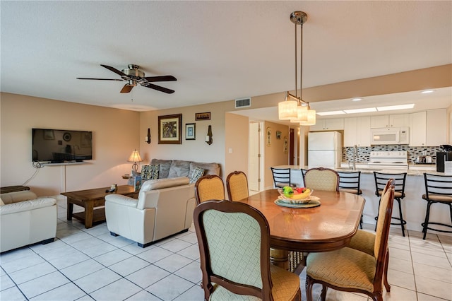 dining space featuring light tile patterned floors and ceiling fan