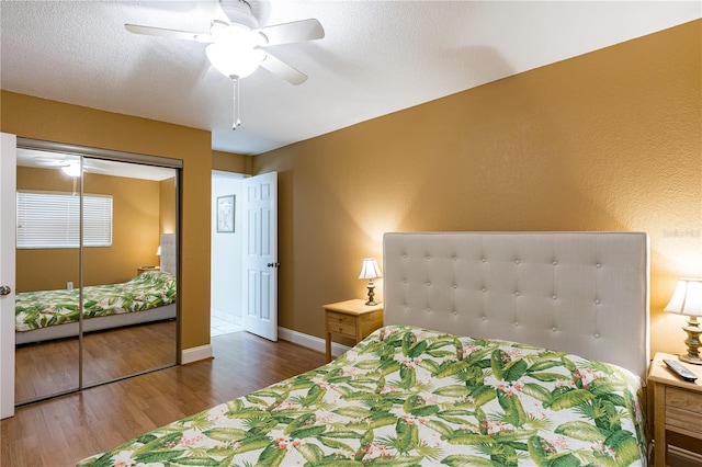 bedroom featuring a textured ceiling, dark wood-type flooring, a closet, and ceiling fan