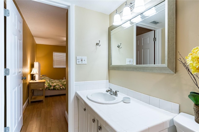 bathroom with vanity, hardwood / wood-style floors, and toilet