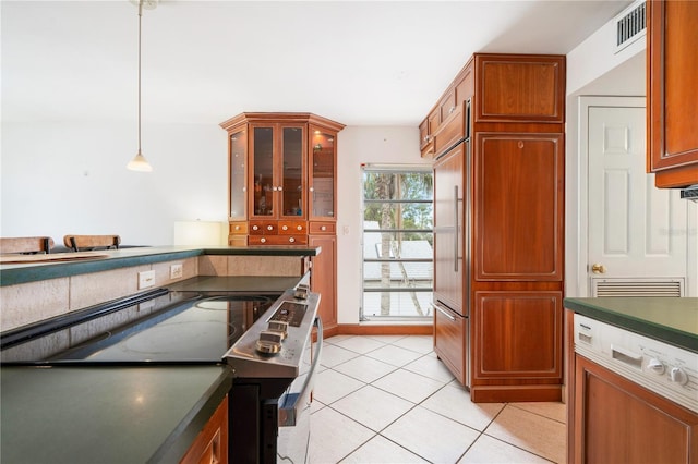 kitchen with stainless steel electric range oven, decorative light fixtures, built in fridge, and light tile patterned floors