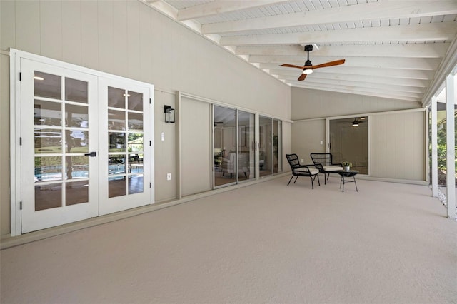 unfurnished sunroom with ceiling fan, vaulted ceiling with beams, and french doors