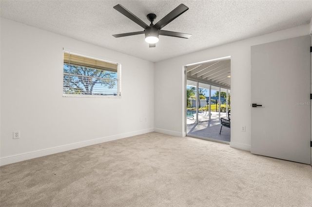 carpeted empty room with a textured ceiling and ceiling fan