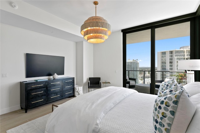 bedroom featuring access to exterior, floor to ceiling windows, and light wood-type flooring