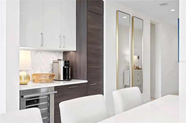 kitchen with white cabinets, beverage cooler, and decorative backsplash