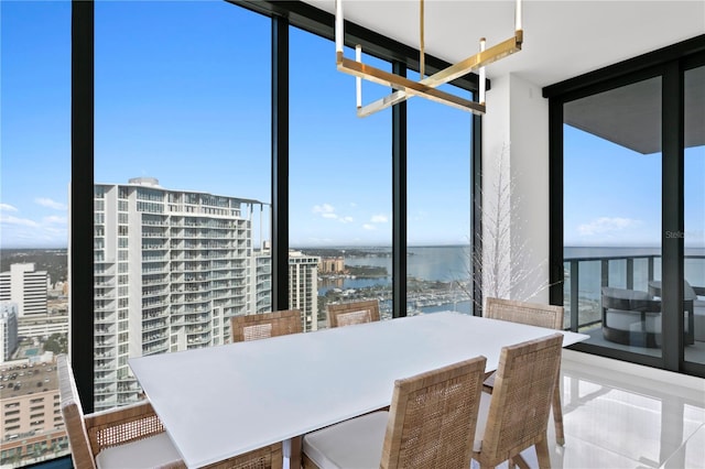 dining room featuring floor to ceiling windows and a water view