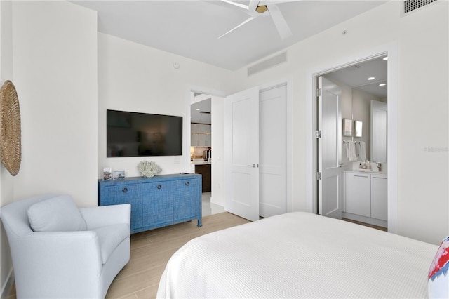 bedroom with connected bathroom and light hardwood / wood-style flooring