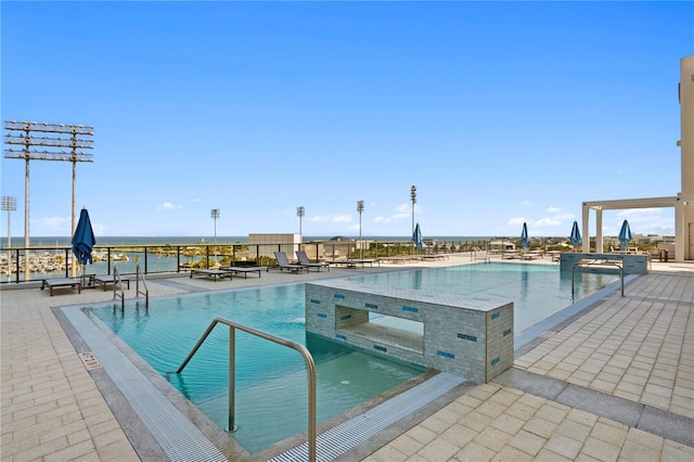 view of pool featuring a patio and a water view