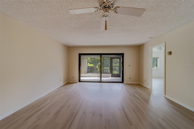 spare room with ceiling fan, light wood-type flooring, and a textured ceiling