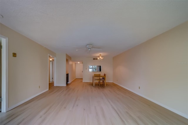 unfurnished room featuring ceiling fan, light wood-type flooring, and a textured ceiling