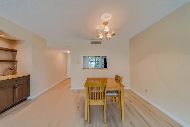 dining room featuring a notable chandelier and light hardwood / wood-style floors