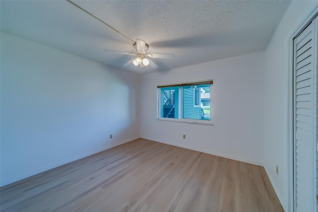 unfurnished bedroom with a textured ceiling, light wood-type flooring, and ceiling fan