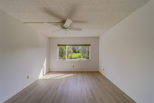 empty room featuring light hardwood / wood-style flooring, a textured ceiling, and ceiling fan