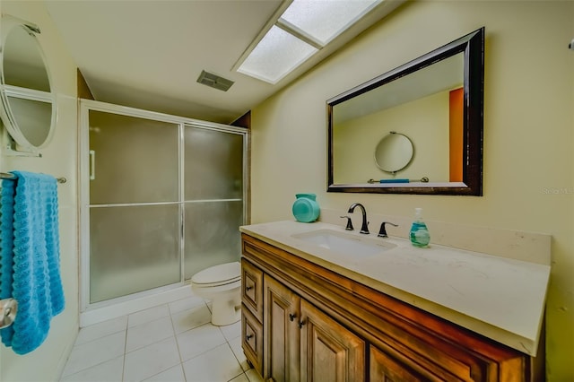 bathroom featuring vanity, walk in shower, tile patterned flooring, and toilet