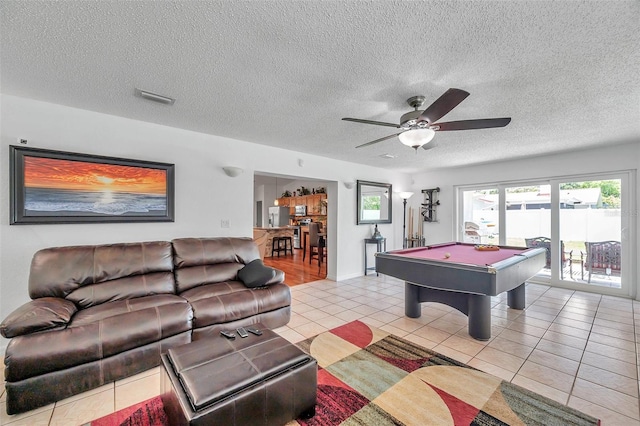 game room featuring pool table, a textured ceiling, light tile patterned floors, and ceiling fan