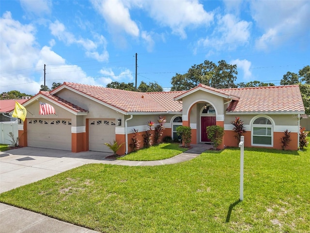 mediterranean / spanish house featuring a garage and a front lawn