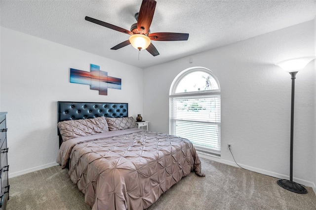 bedroom featuring ceiling fan, light colored carpet, and a textured ceiling