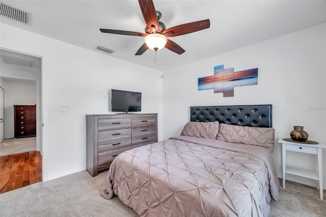 carpeted bedroom with a textured ceiling and ceiling fan