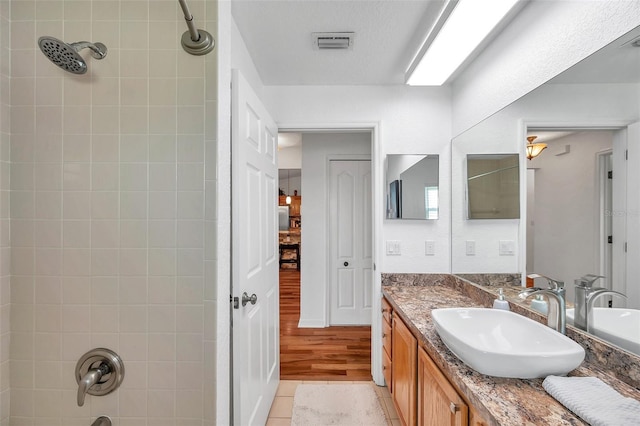 bathroom featuring vanity, tiled shower / bath combo, and wood-type flooring