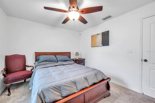 carpeted bedroom featuring a textured ceiling and ceiling fan