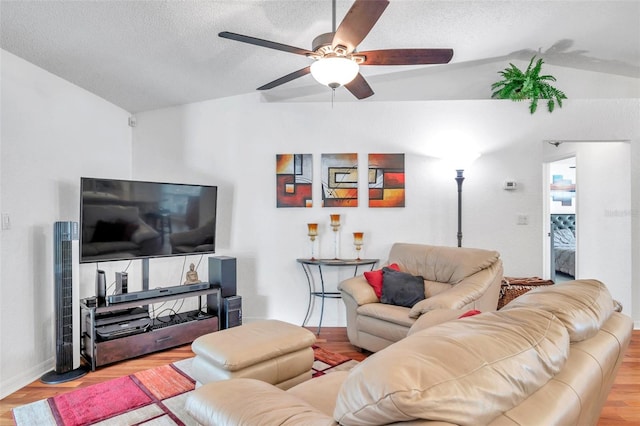 living room with light wood-type flooring, a textured ceiling, ceiling fan, and vaulted ceiling