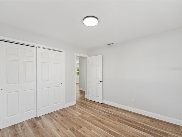 unfurnished bedroom featuring a closet and light wood-type flooring