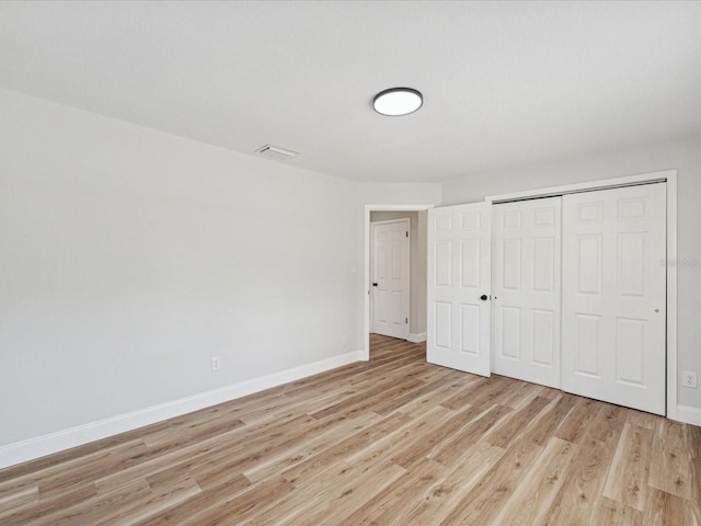 unfurnished bedroom featuring a closet and light hardwood / wood-style flooring