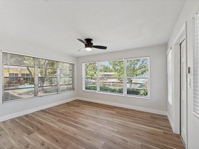 unfurnished sunroom with ceiling fan