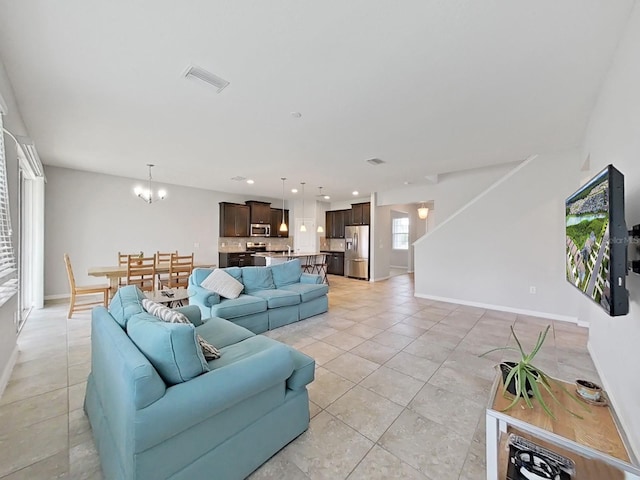 living room with a notable chandelier and light tile patterned flooring