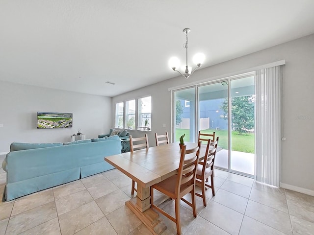 tiled dining room featuring a chandelier