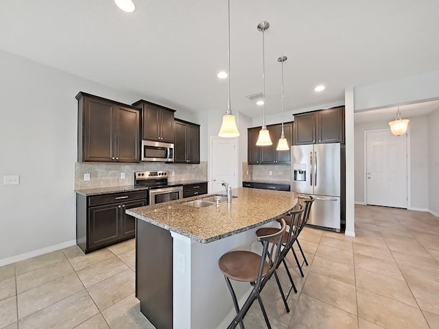 kitchen featuring backsplash, light stone countertops, sink, light tile patterned flooring, and stainless steel appliances