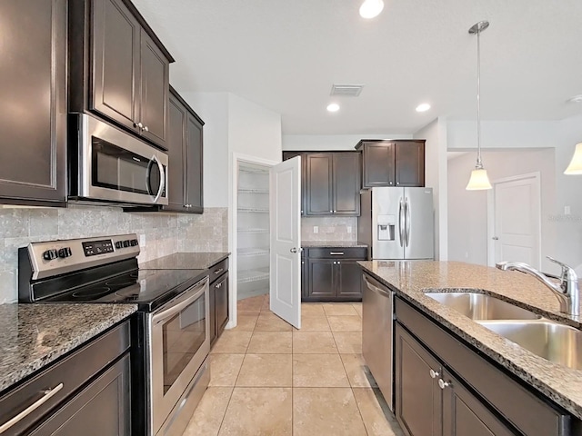 kitchen featuring dark brown cabinetry, visible vents, stainless steel appliances, pendant lighting, and a sink