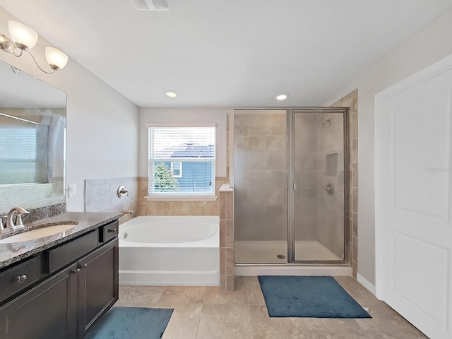 bathroom with tile patterned flooring, independent shower and bath, and vanity