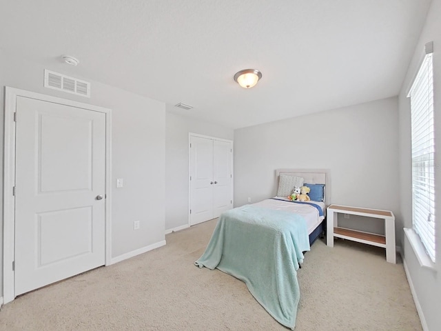 bedroom featuring visible vents, light carpet, and baseboards