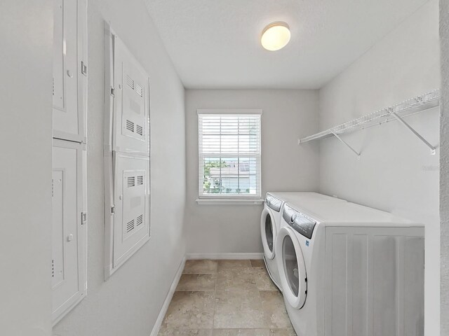 laundry room with independent washer and dryer and light tile patterned floors