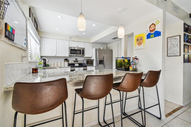 kitchen with white cabinetry, light tile patterned floors, kitchen peninsula, stainless steel appliances, and sink