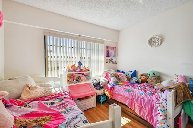 bedroom with a textured ceiling and hardwood / wood-style flooring