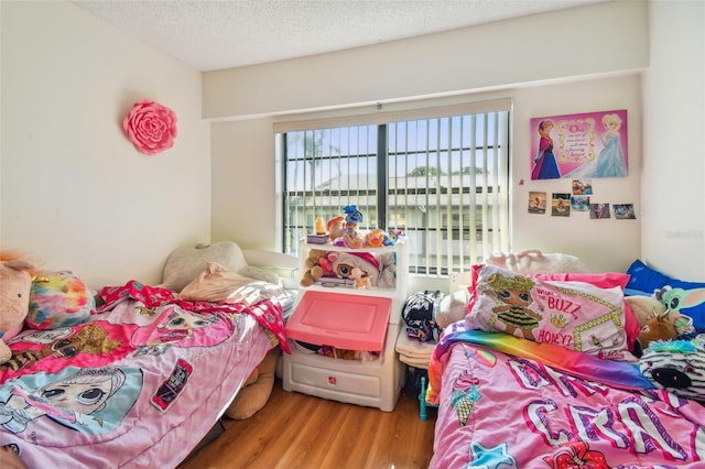 bedroom with a textured ceiling and wood-type flooring