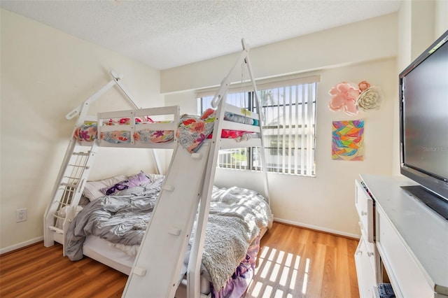 bedroom with a textured ceiling and light hardwood / wood-style floors