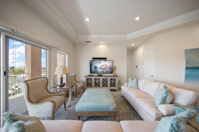 living room with a raised ceiling and ornamental molding