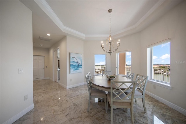 dining area with a raised ceiling, crown molding, a water view, and a notable chandelier