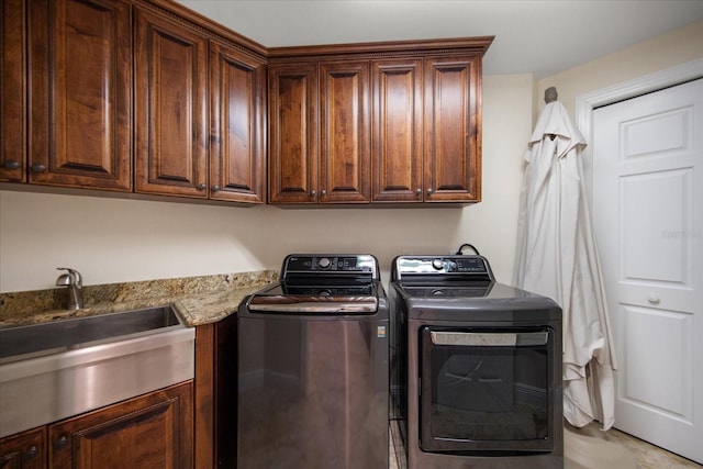 laundry area featuring cabinets, sink, and independent washer and dryer