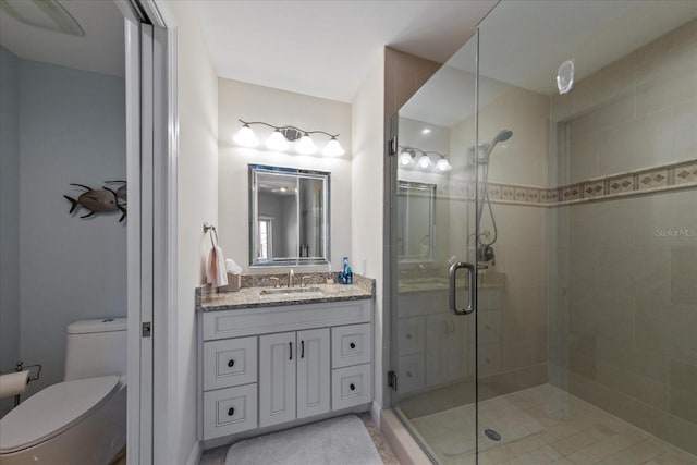 bathroom with a shower with door, vanity, and toilet