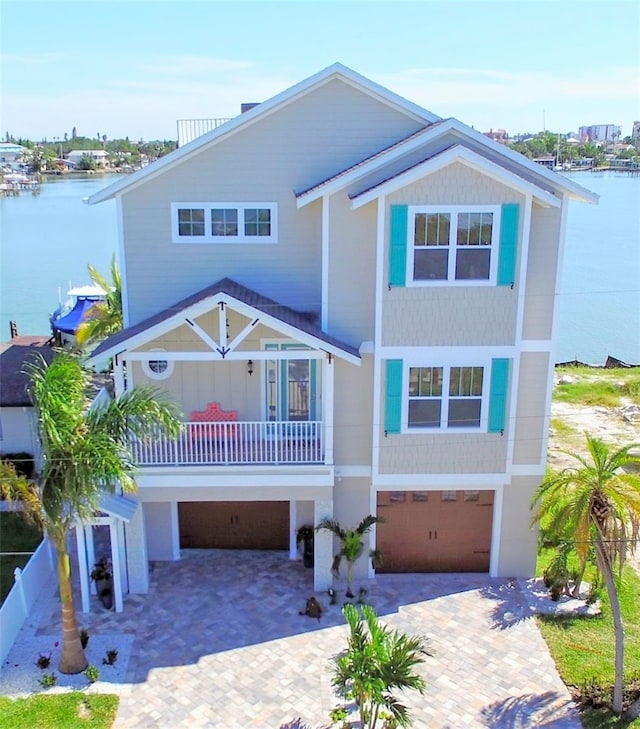 view of front of home featuring a water view, a balcony, and a garage