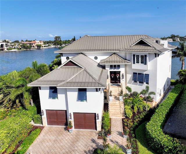 view of front of house featuring a garage and a water view