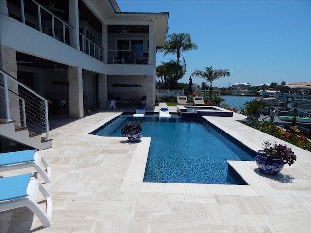 view of pool with a water view, an in ground hot tub, and a patio