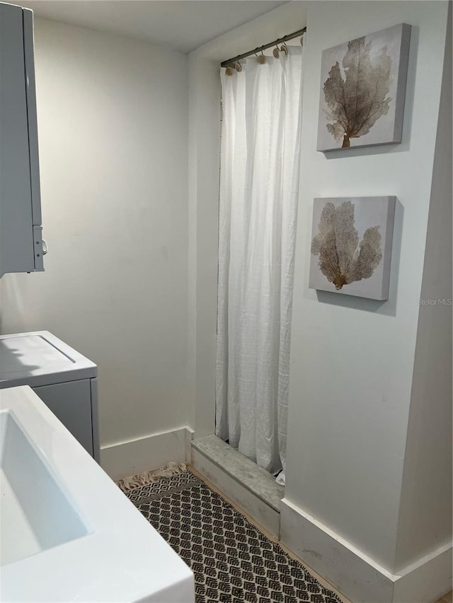 bathroom featuring washer / dryer and a shower with curtain