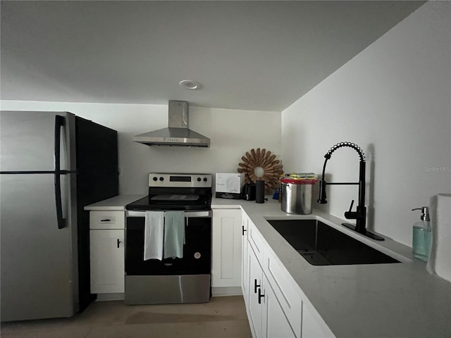 kitchen featuring wall chimney range hood, white cabinets, stainless steel appliances, and sink