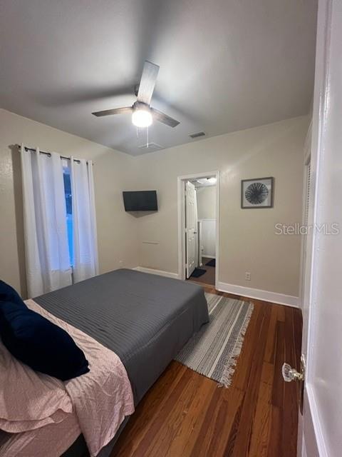 bedroom featuring dark wood-type flooring, connected bathroom, and ceiling fan