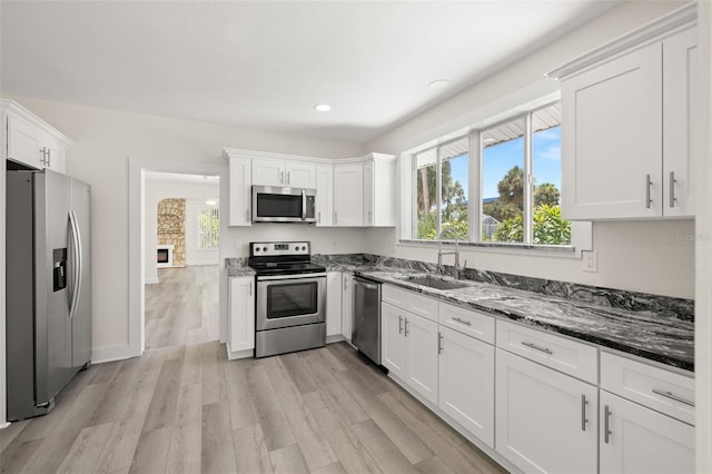 kitchen featuring white cabinetry, dishwashing machine, refrigerator, stove, and sink